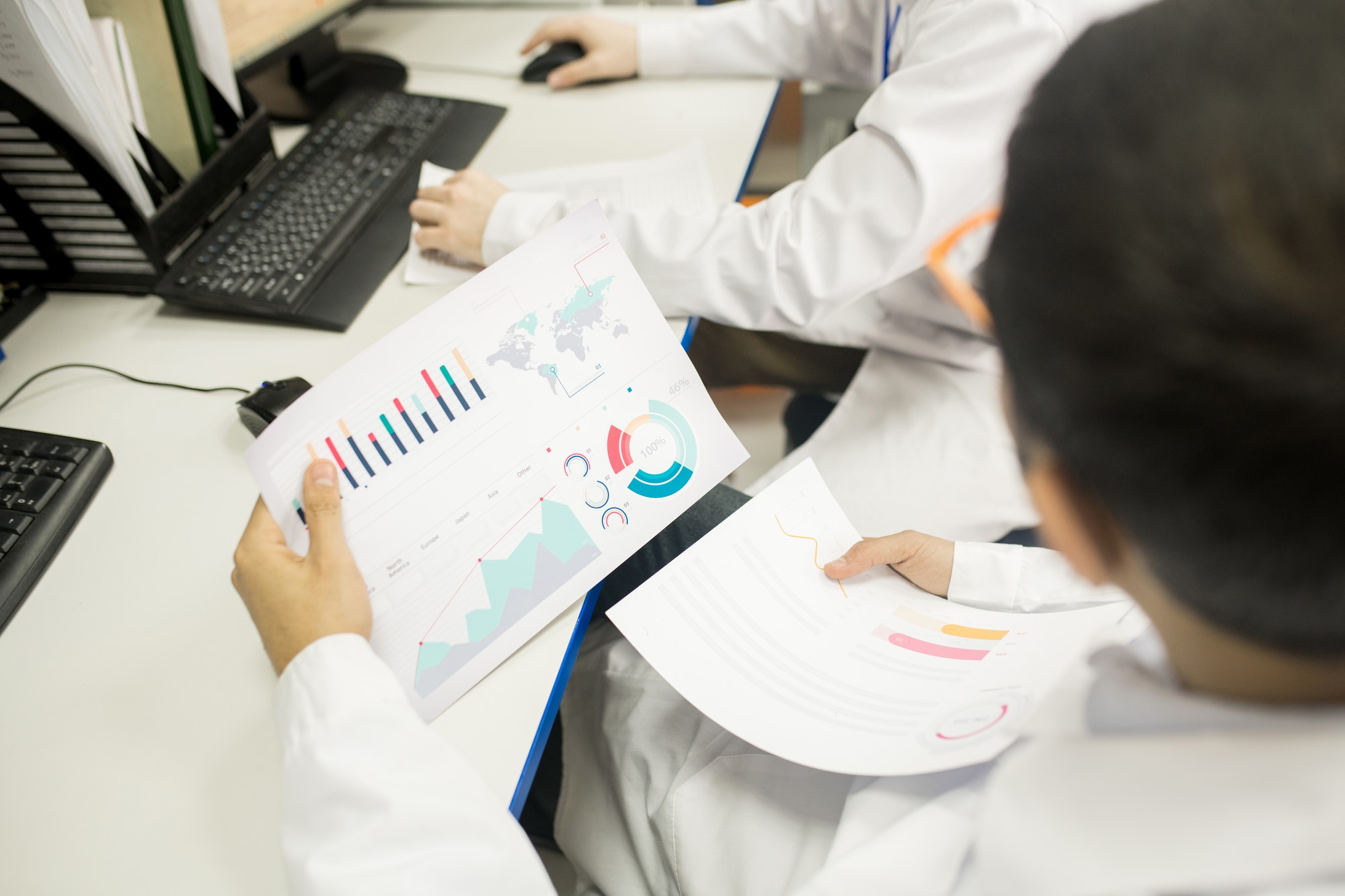 Technicians analyzing charts in factory office